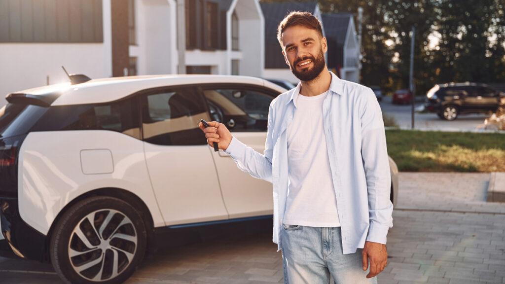 En forretningsmand med nøglerne til en ny elbil, der giver en lavere beskatning af fri bil 2026 i forhold til dieselbiler.