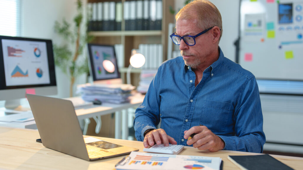 Sygemelding regler arbejdsgiver 2026: Få styr på løn og refusion En virksomhedsejer der beregner de økonomiske konsekvenser ved de gældende sygemelding regler arbejdsgiver 2026 i arbejdsgiverperioden.